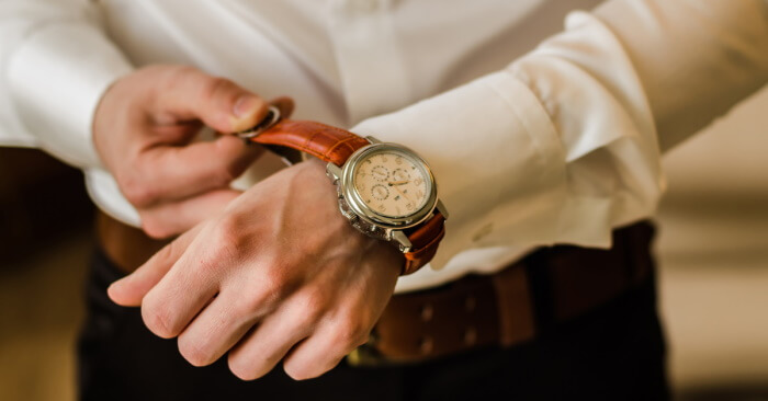 A man fastening the strap of a collectable watch on his wrist