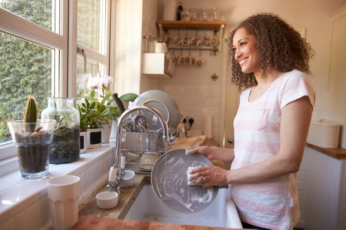 Woman standing at kitchen sink