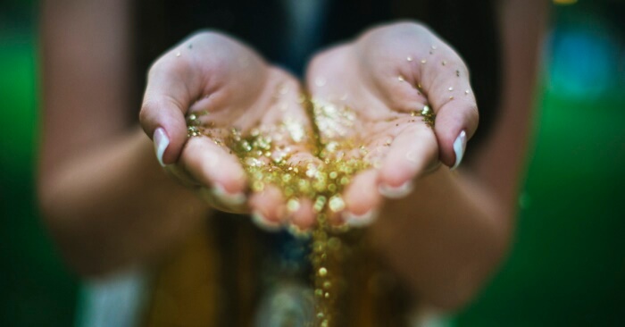 Woman holding gold glitter in her hands