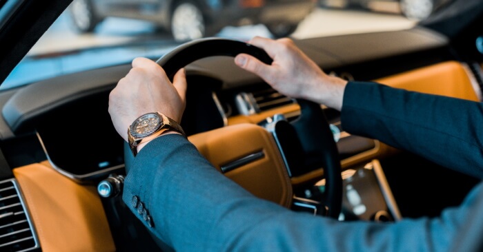 Businessman with high-end watch sitting in car