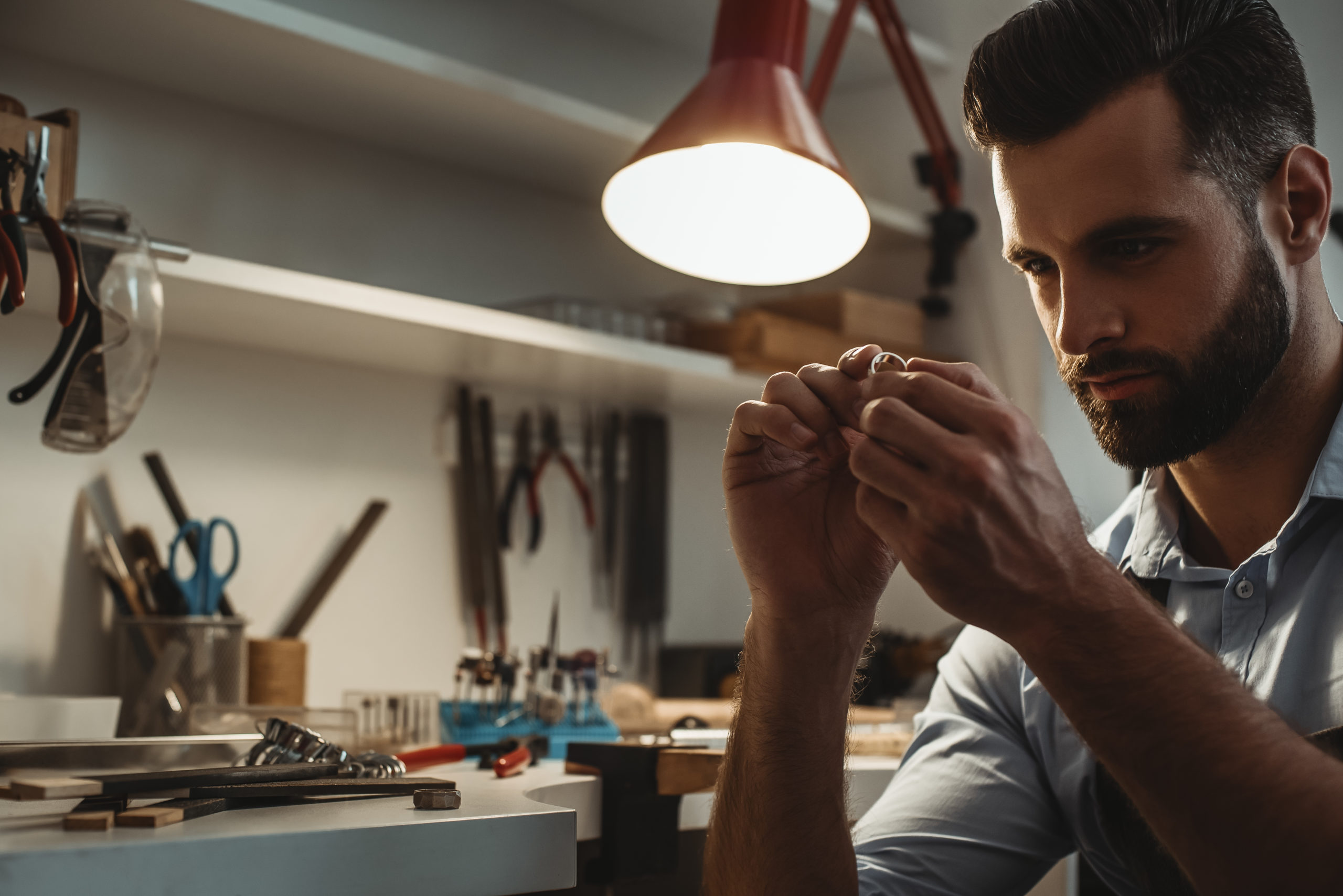 Man closely examining an item of jewelry.