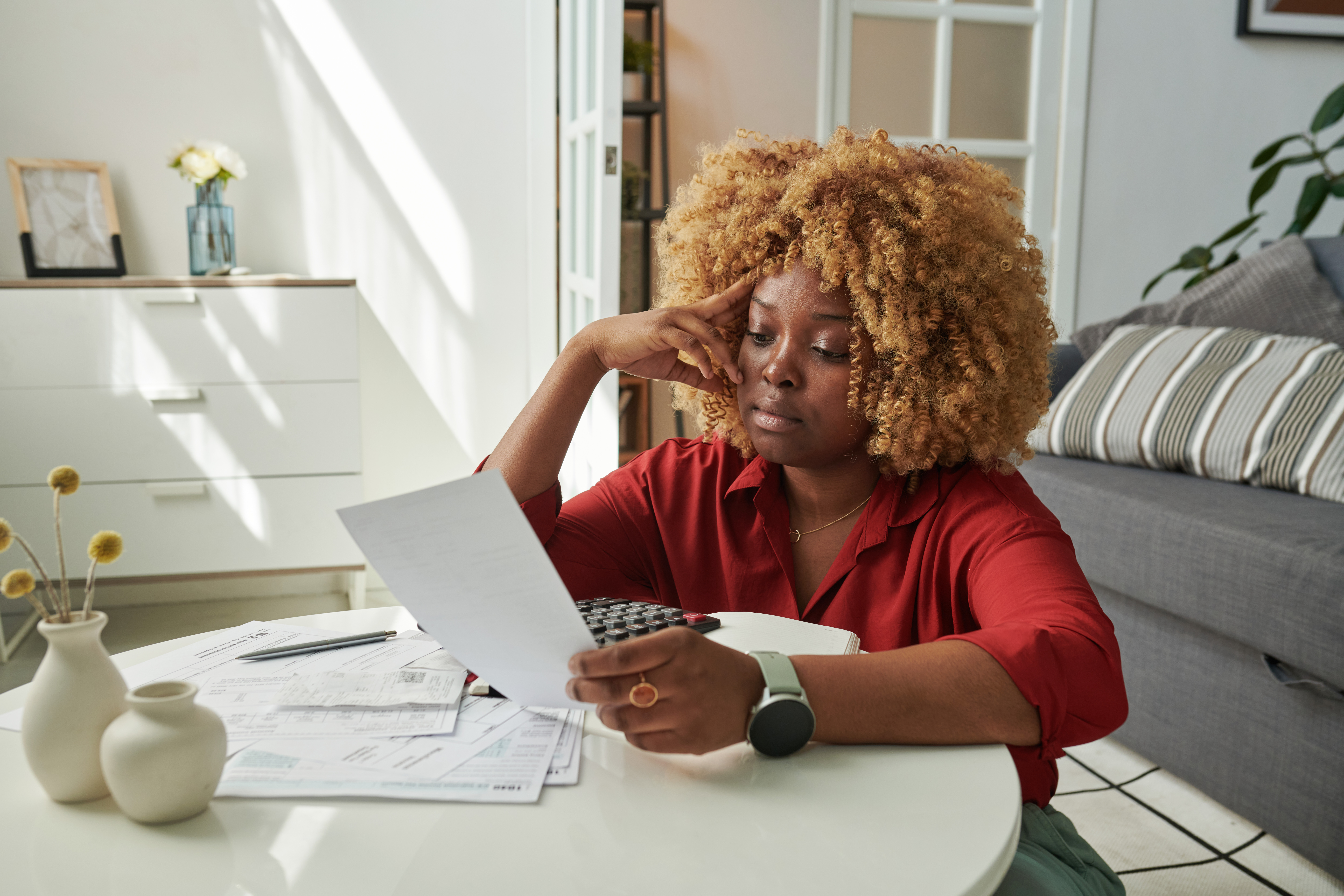 A woman sitting at her table looking over paperwork for a loan.